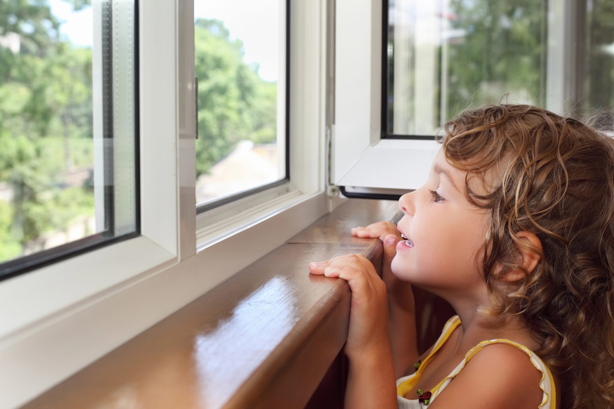 A young boy looking out from a window