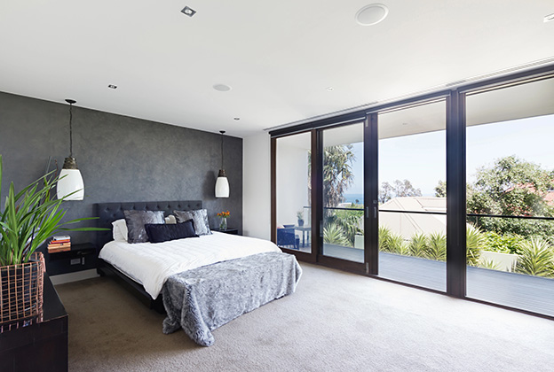 A cozy bedroom with light coming in from the glass doors